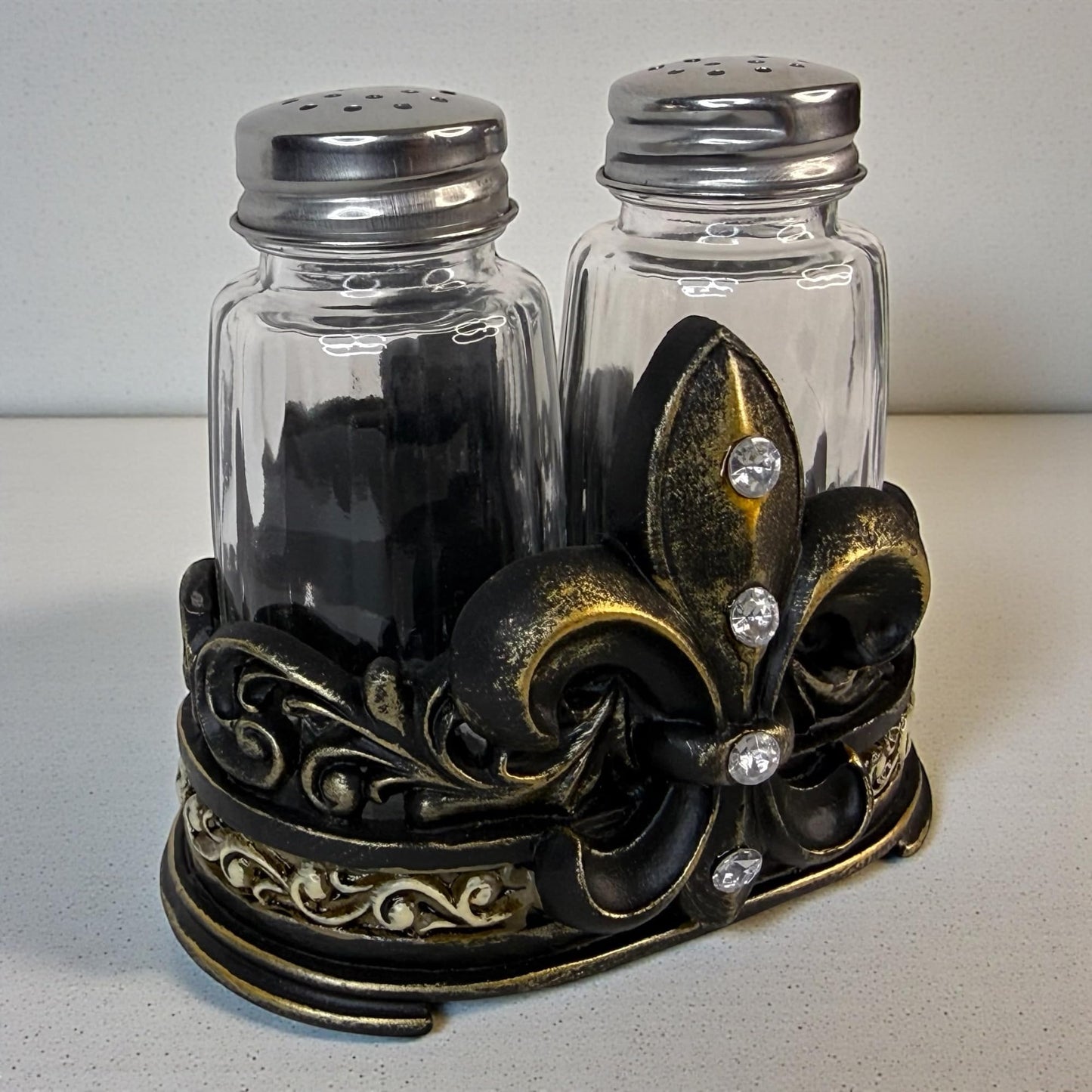 Fleur De Lis Salt and Pepper Shaker Set with Decorative Resin Holder – Glass Shakers with Stainless Steel Lids – French Country Cajun Kitchen Decor – 3 3/4” Tall Tabletop Seasoning Set