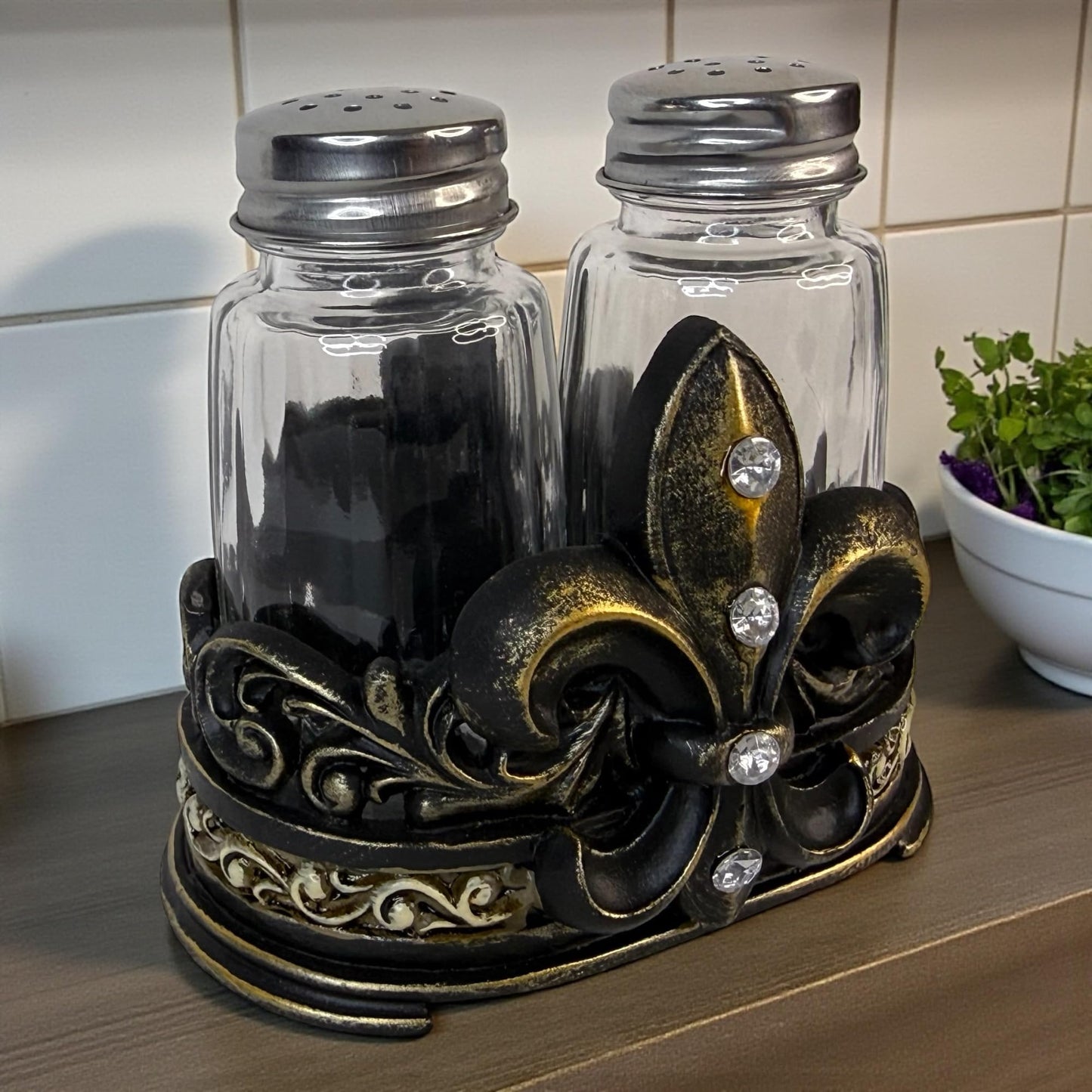 Fleur De Lis Salt and Pepper Shaker Set with Decorative Resin Holder – Glass Shakers with Stainless Steel Lids – French Country Cajun Kitchen Decor – 3 3/4” Tall Tabletop Seasoning Set